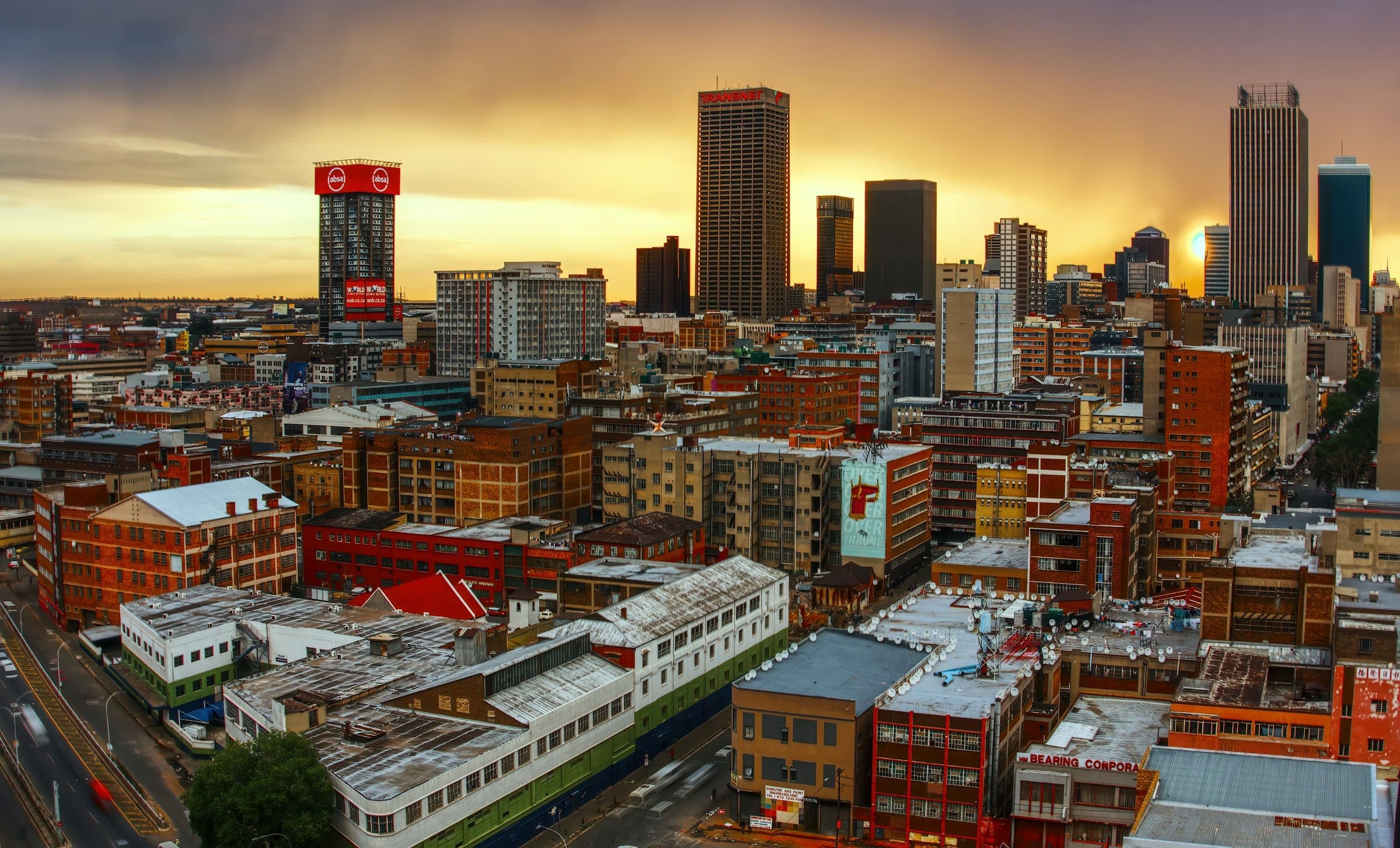 High-angle view of the Johannesburg skyline under a warm golden hour sky