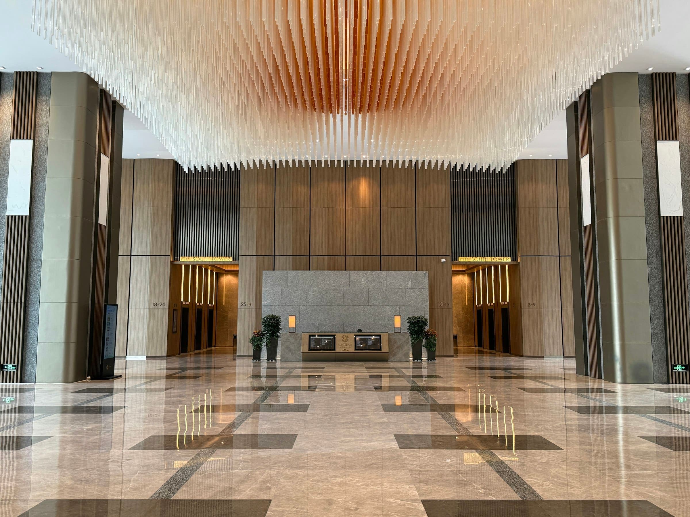 Spacious modern lobby with marble floors, tall columns and a reception desk